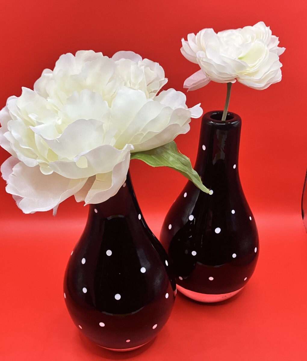 Uitgelichte afbeelding voor “Twee vaasjes van zwart glas met witten stippen en kunstbloemen”